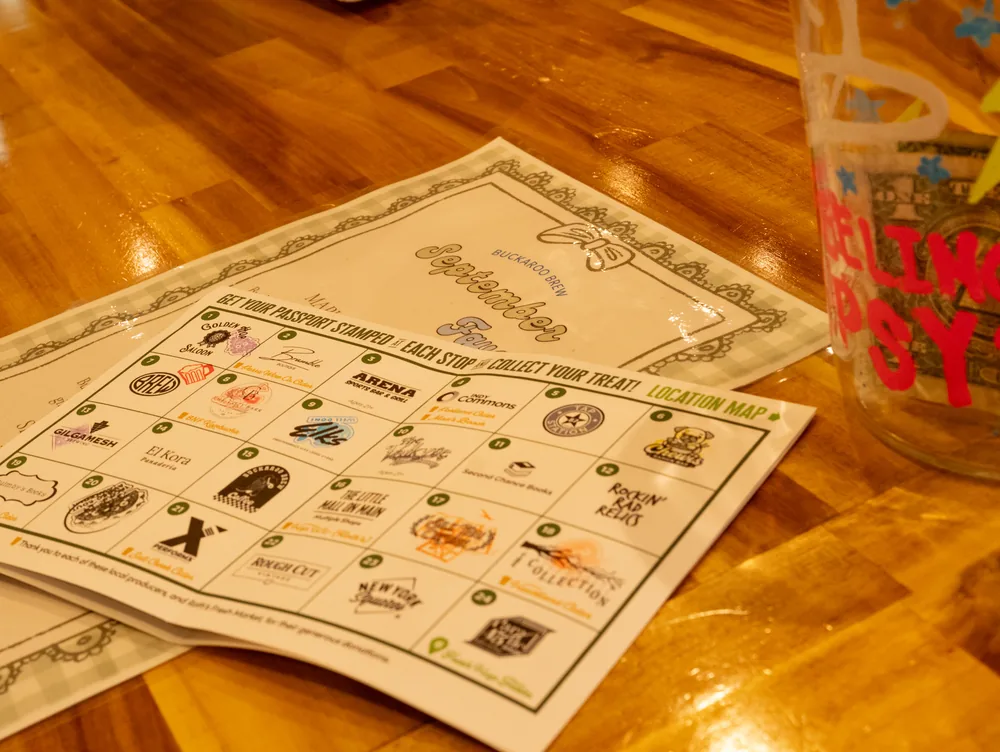 A Downtown Passport card resting on a bar top beside a festival tasting glass